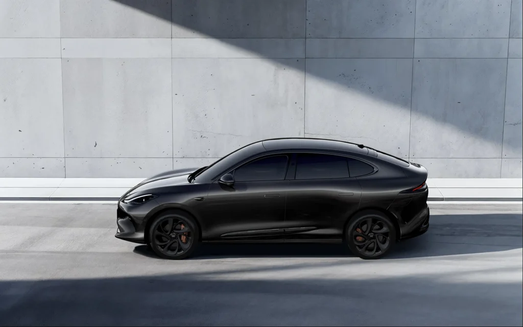 Svart MG IM6 sedan med sotede vinduer ved betongvegg.